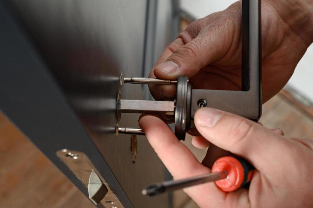 Hands installing a door handle.