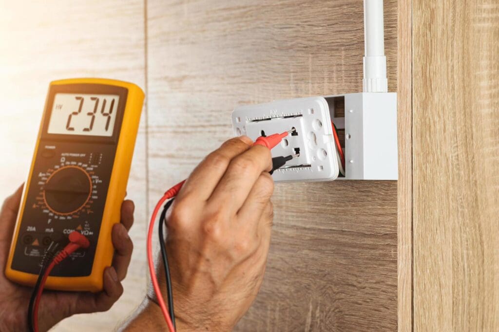 Electrician testing electrical outlet voltage.